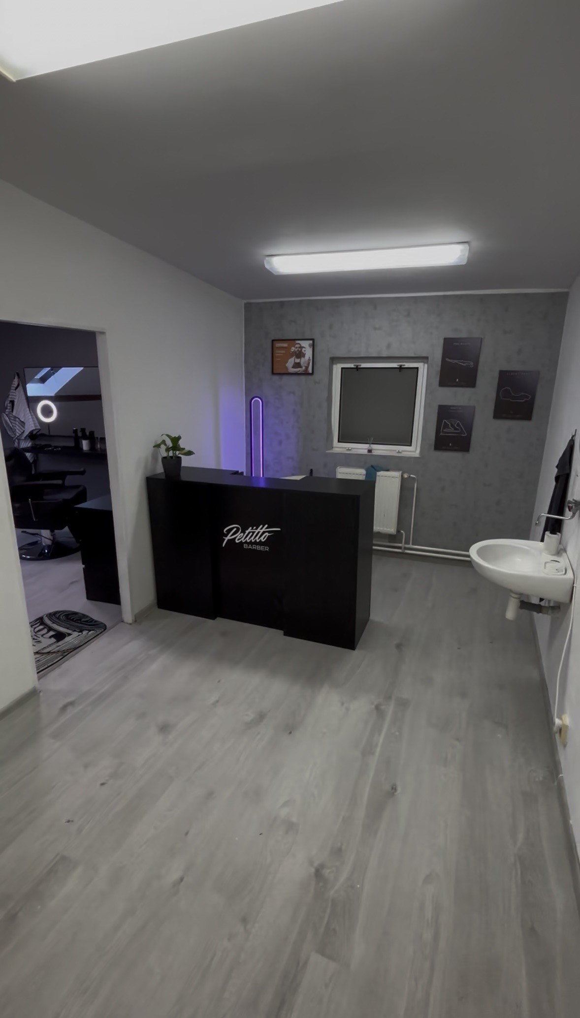 Recepce Petitto Barber s logem na pultu